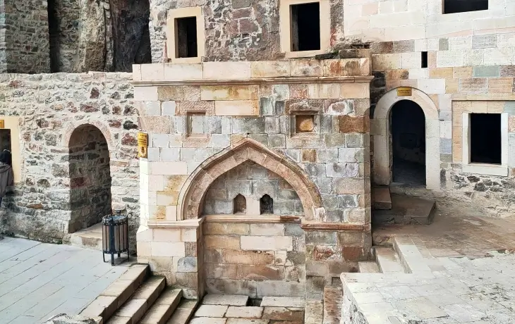 Sümela Manastırı’ndaki ayazma yapısı; kemerli nişleri, taş işçiliği ve kutsal suyun aktığı bölümün mimari detaylarıyla birlikte görünüm.